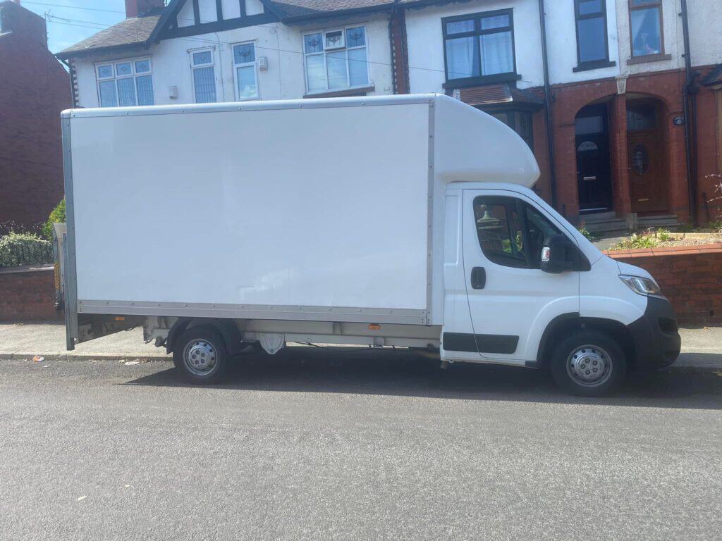 How Many Removal Vans Do I Need for My House Move? White Luton removal van viewed from the side, parked on a residential street.